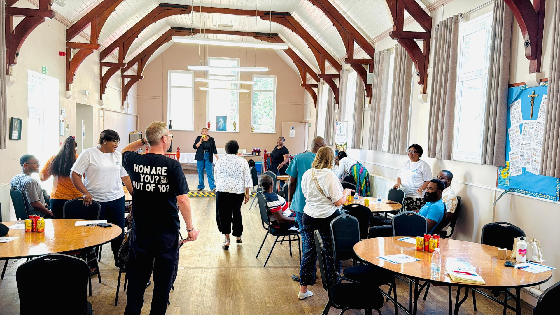 Community members talking together at a wellbeing session in a church hall